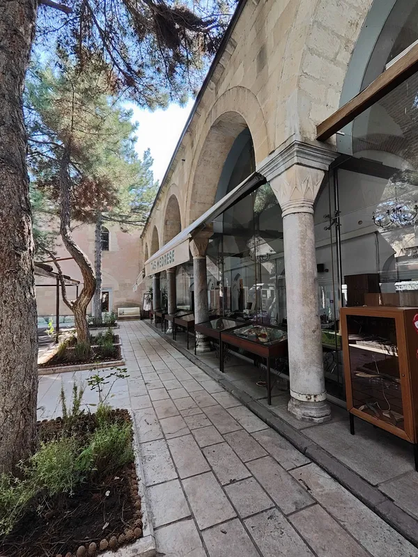 Geniş koridor, yuvarlak kemerler ve taş döşeme ile tarihi atmosfer sunuyor.