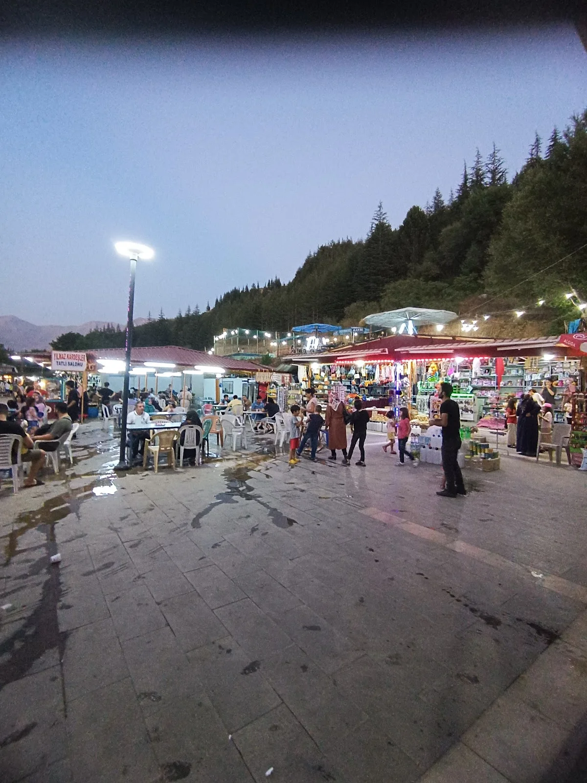Ekinözü İçmeleri - Renkli Turistik Pazar Deneyimi: Alışverişin keyfi Turistik pazar alanında plastik sandalyeler, masalar ve hediyelik eşya dükkanları yer alıyor.