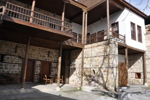 Taş ve ahşap malzemelerle inşa edilmiş geleneksel bir konağın dış görünümü.