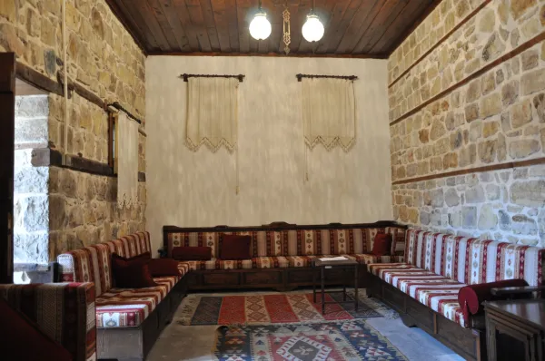 Geleneksel taş duvarlar ve rustik ahşap detaylarla dekore edilmiş bir iç mekân