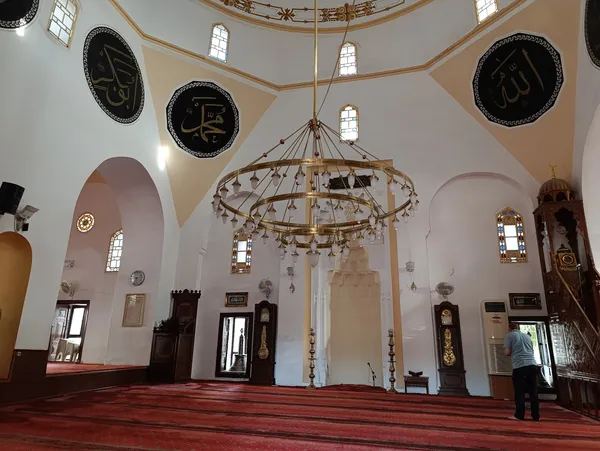 Aydınlık cami iç mekanında işlemeli minber ve avize.