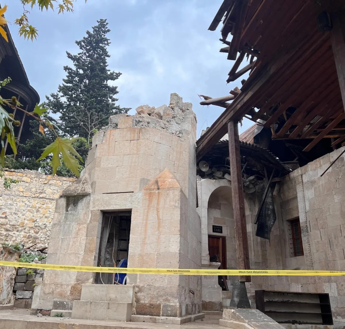Tarihi Duruş: Yıkılmış Hatuniye Camii'nin Taş Duvarları ve Hasarlı Çatısı Yıkılmış Hatuniye Camii'nin taş duvarları ve hasar görmüş çatısı