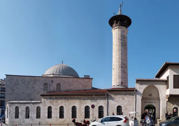 Silindirik minaresi ve geniş pencereleriyle Habibi Neccar Camisi, açık mavi gökyüzü altında etkileyici bir yapı.