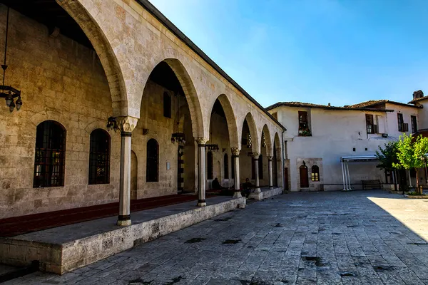 Tarihi Habibi Neccar Camisi avlusunda kemerli sütunlar ve modern yapılar yer almakta.