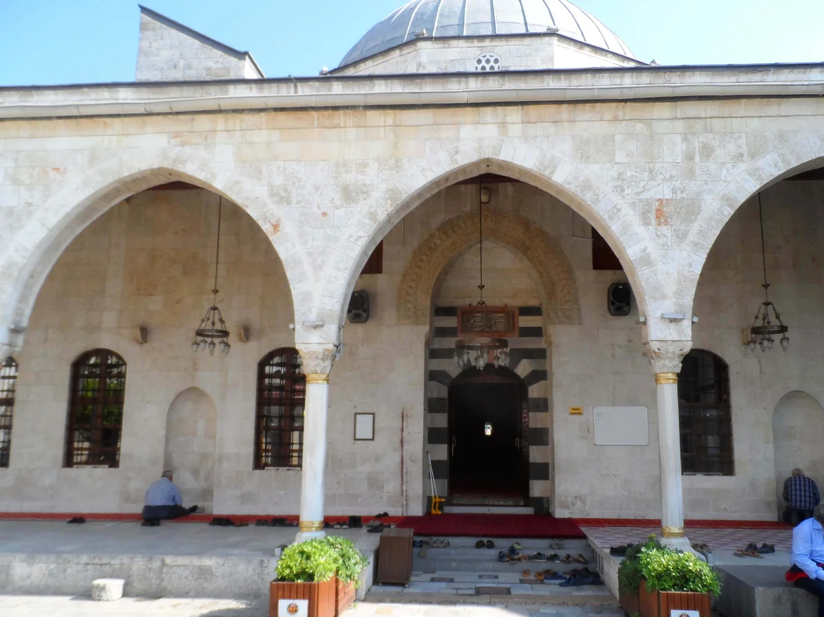 Zarif Avlu: Kemerler ve kubbeyle süslü Habibi Neccar Camisi Geniş kemerler ve kubbe ile süslü Habibi Neccar Camisi'nin avlusu, ibadet eden kişilerle huzurlu bir atmosfer sunuyor.