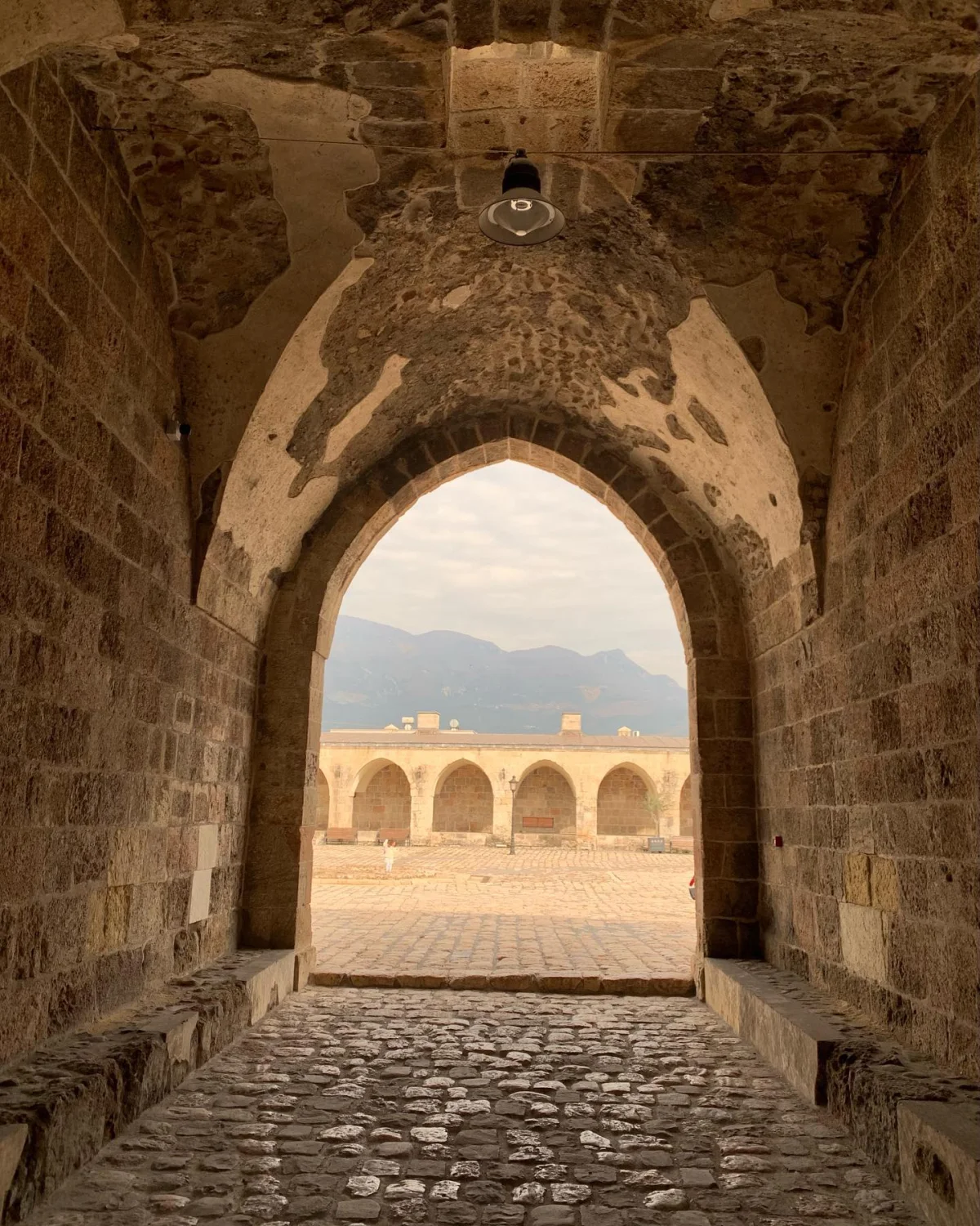 Taş Kemer ve Avlu - Payas Kalesi'nin İçsel Güzelliği! Taş bir yapının içinden dışarıya bakan büyük kemer ve avlu görünümü