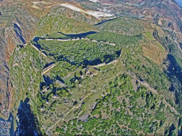 Yeşil bitki örtüsü ile çevrili dağlık alanda Antakya Kalesi'nin kalıntıları görünmekte.
