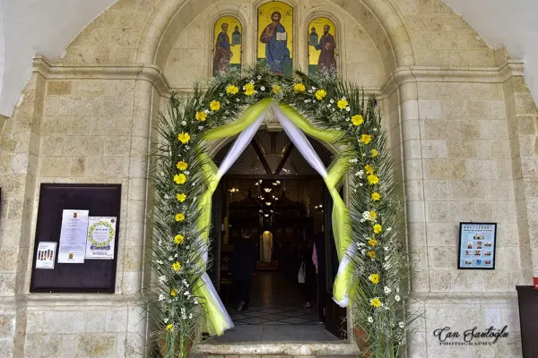 Ortodoks kilisesinin girişinde, ikonalar ve yeşil yapraklar süslemeleriyle dikkat çekiyor.