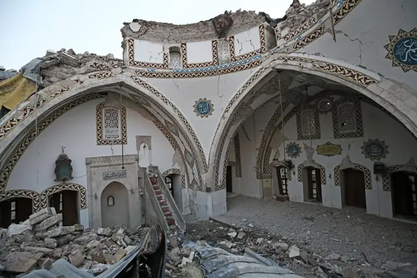 Yıkılmış tavan ve duvarlarla Osmanlı süslemesi görünümdeki cami iç mekanı.