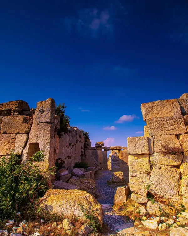 Taş duvarlarla çevrili tarihi kalıntılar ve mavi gökyüzü