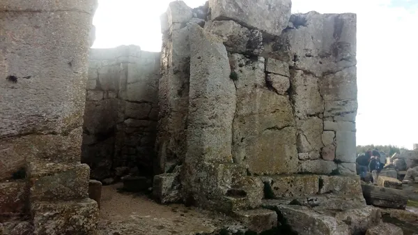 Taş duvarlarla çevrili St Simon Manastırı kalıntıları, ziyaretçilerle aydınlık bir ortamda.
