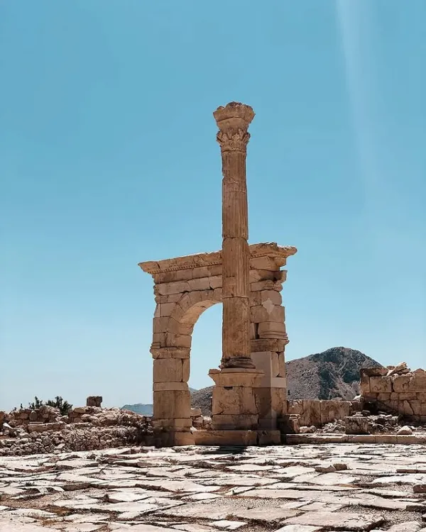 Açık mavi gökyüzü altında yüksek sütun ve taş bloklar