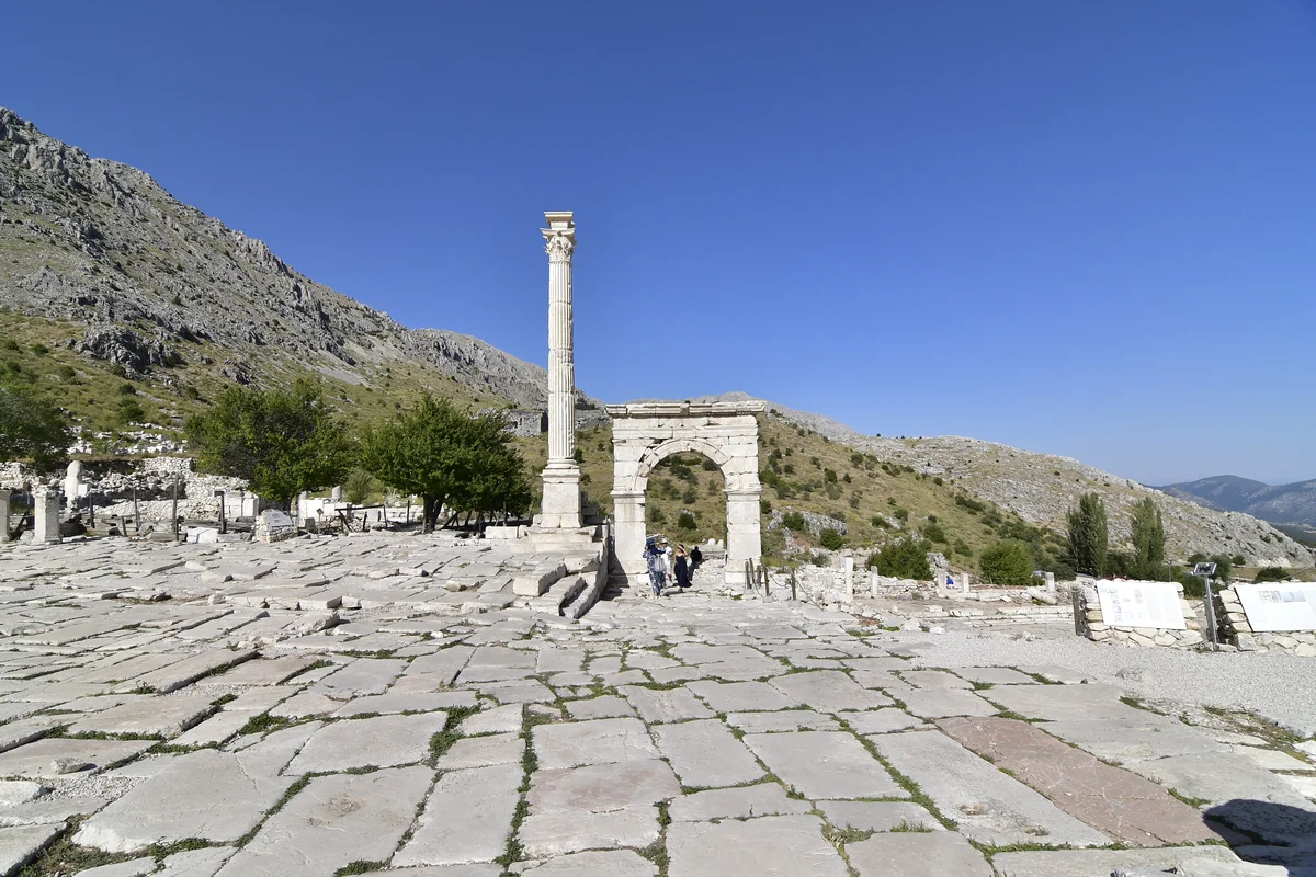 Tarihin İzinde: Antik Kalıntılar ve Dağlar! Yüksek dağlar arasında antik kalıntılar ve gezginler görülüyor.