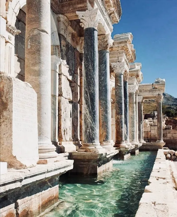 Antik Sagalassos'taki beyaz taş sütunlar ve suyla dolu havuz.