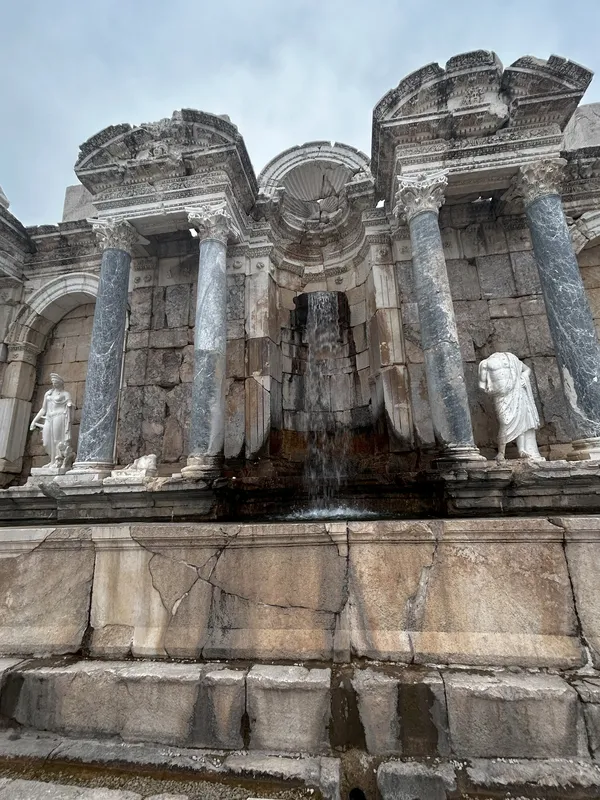 Antik yapının ön cephesi, su dökümü ve zarif taş işçiliği ile dikkat çekiyor.