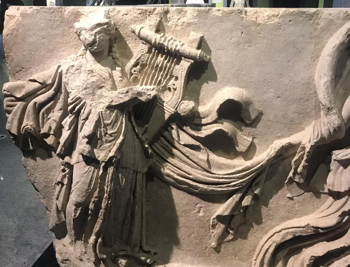 Sanat ve Müzik: Burdur Müzesi'nde Antik Kabartma Figür Antik bir yapıtta yer alan, elinde saz tutan ciddi yüz ifadesine sahip figür.
