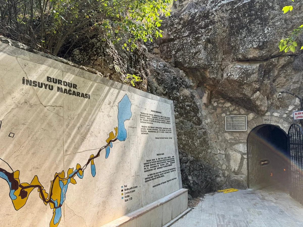 Burdur İnsuyu Mağarası'nın girişi, çevresindeki yeşil bitkilerle birlikte gösterilmektedir.