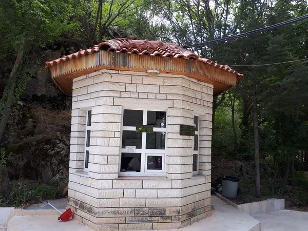 Sekizgen yapıda ahşap çatılı bilgi ofisi, yeşil ağaçlarla çevrili doğal ortam.