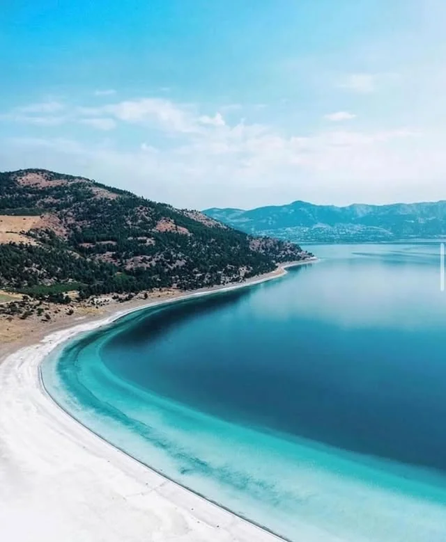 Huzur Verici Manzara - Açık Mavi Deniz ve Beyaz Kum Şeridi Açık mavi deniz ve ince beyaz kum şeridiyle huzur verici manzara.