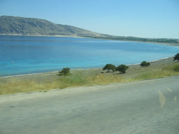 Berrak mavi su ve plajıyla Salda Gölü'nün huzur verici manzarası.