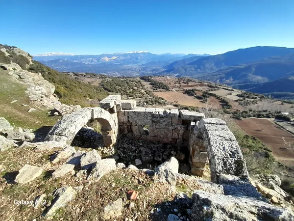 Yemyeşil dağlar önünde yer alan Kremna antik kentinin taş kalıntıları.