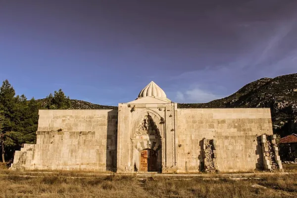 Büyük taş bina, zarif kapı ve kubbe ile yemyeşil dağlar arasında yer alıyor.