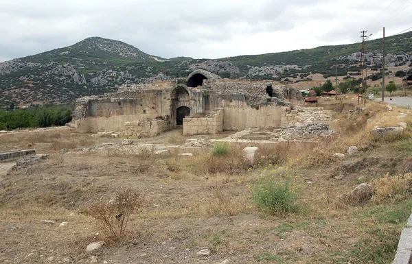 Taşlardan inşa edilmiş yüksek duvarlar ve dağlık arka plan.