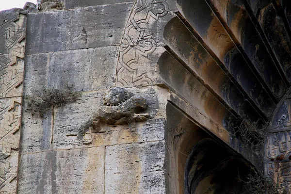 Tarihi yapı duvarındaki detaylı taş işçiliği, geometrik şekiller ve figürler içermektedir.