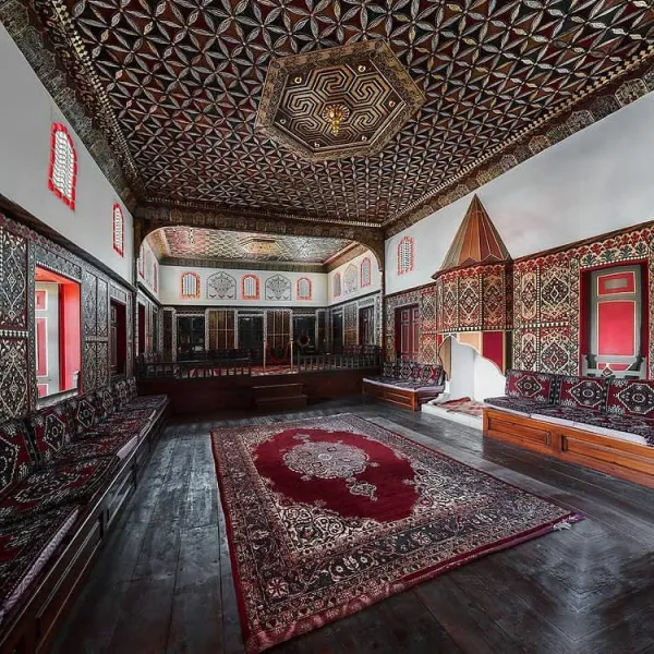 Geleneksel bir odanın iç mekanında zengin motifler ve ahşap detaylar dikkat çekiyor.