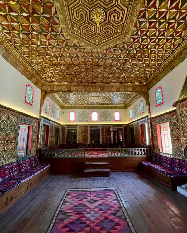 Zengin mimari detaylara sahip otantik bir iç mekan, geometrik tavan ve renkli pencerelerle dolu.
