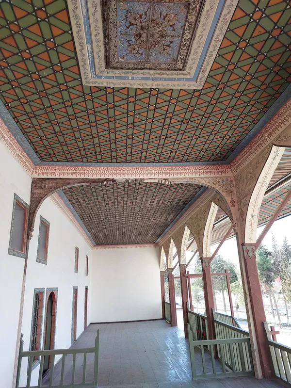 Bakibey Konağı'nın tavanı geometrik desenlerle süslü, beyaz duvarlar ve ahşap korkuluklar dikkat çekiyor.