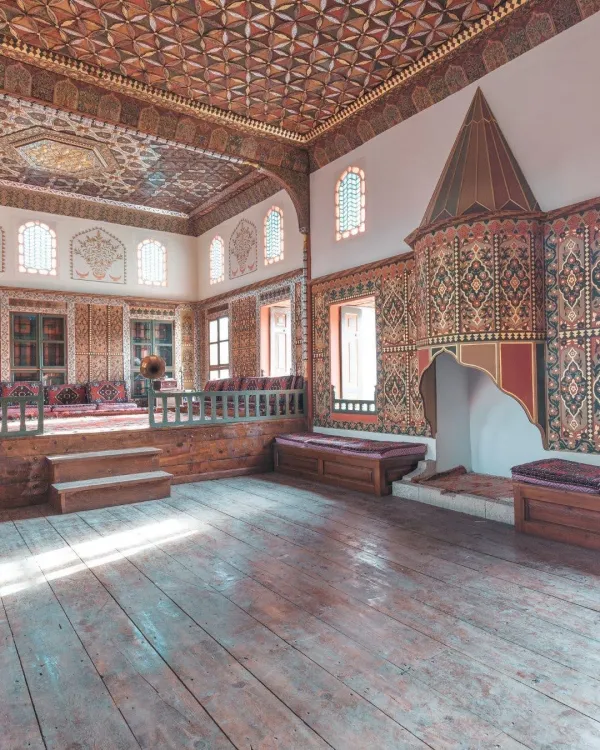 Geleneksel iç mekan, zengin süslemeleri ve ahşap zemin ile dikkat çekiyor.