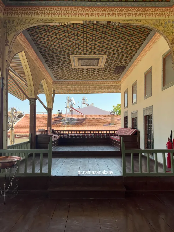 Tarihi bir yapıda süslü tavan ve geleneksel oturma alanı görünmektedir.