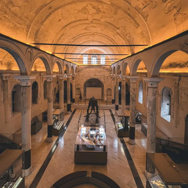 Tarihi müze iç mekanında yüksek kemerli tavan ve büyük heykel yer alıyor.
