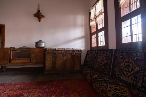 Beyaz duvarlar, ahşap zemin ve geleneksel oturma grubu ile sıcak bir iç mekan