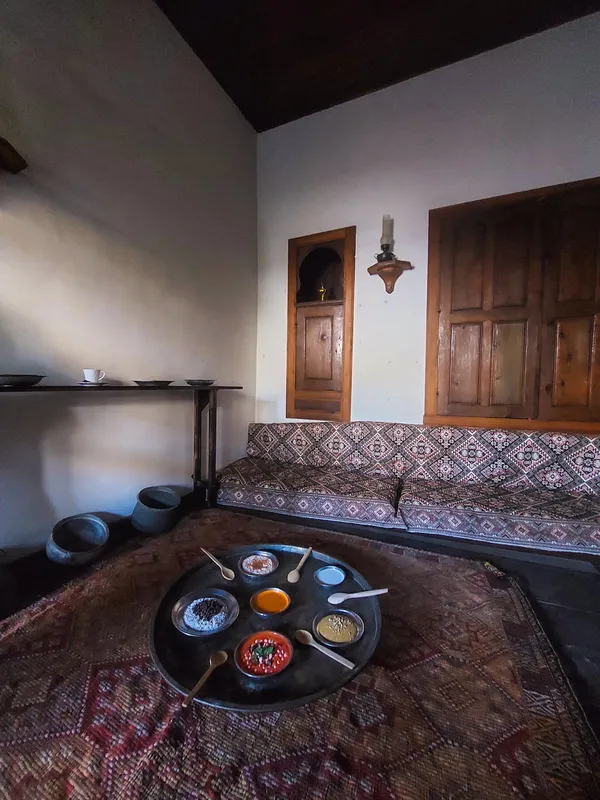 Sade duvarlar, ahşap detaylar ve büyük bir tepsi içinde soslarla dolu sıcak bir oturma alanı.