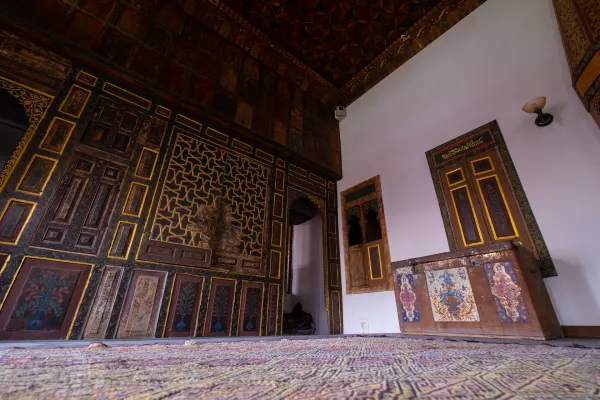 Zengin geometrik desenli tavan ve ahşap işçiliğiyle süslü geleneksel iç mekan