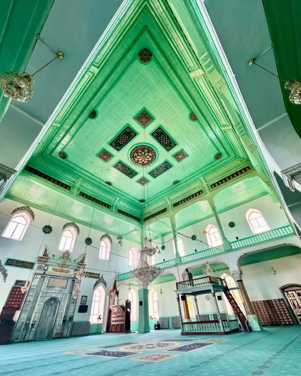 Yeşil tonlarında, detaylı desenlerle süslenmiş cami iç mekânı