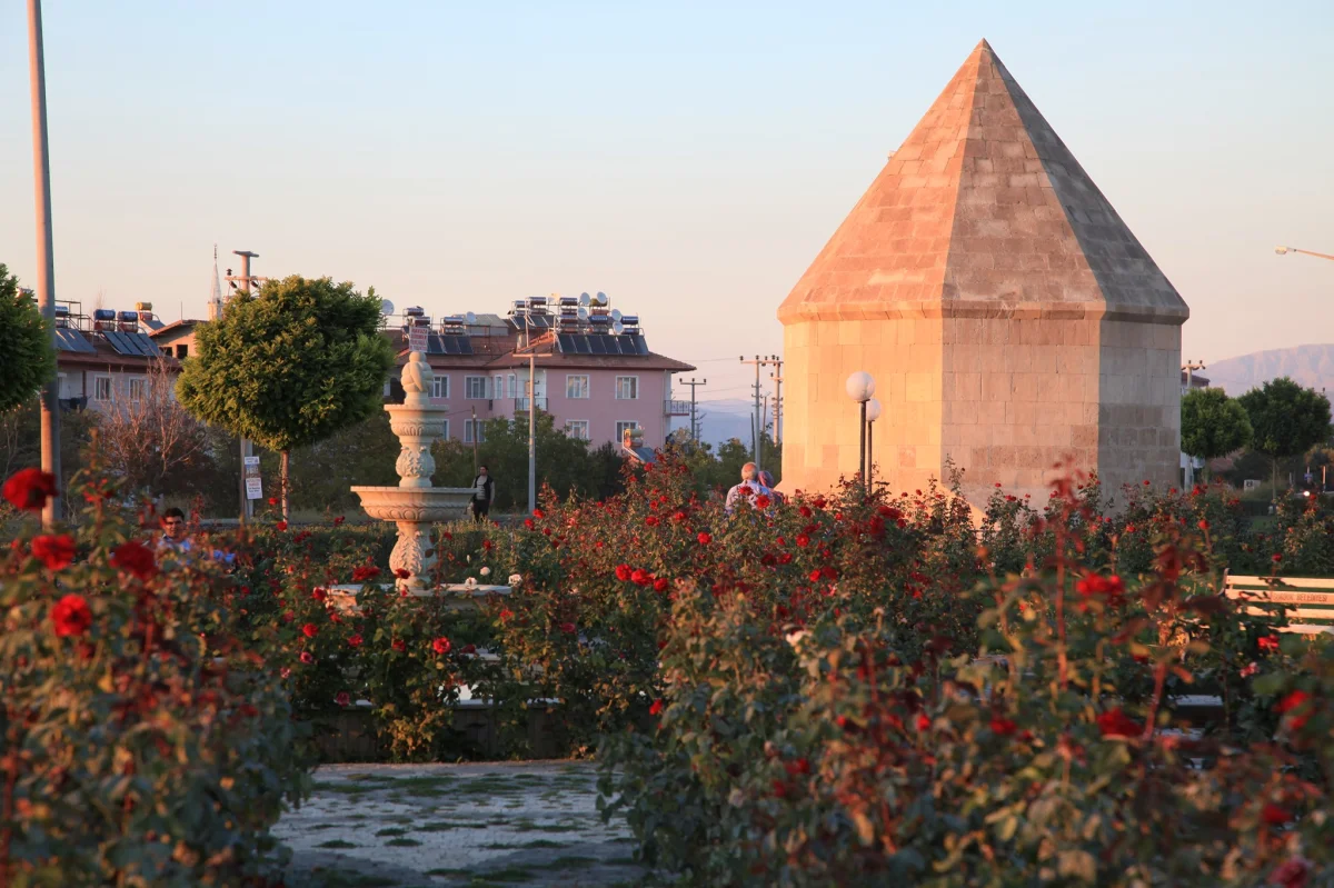 Dörtayak Türbesi ve Gül Bahçesi - Burdur'un Saklı Cenneti! Dörtayak türbesinin yer aldığı park alanında gül çiçekleri ve yürüyüş yapan insanlar yer alıyor.