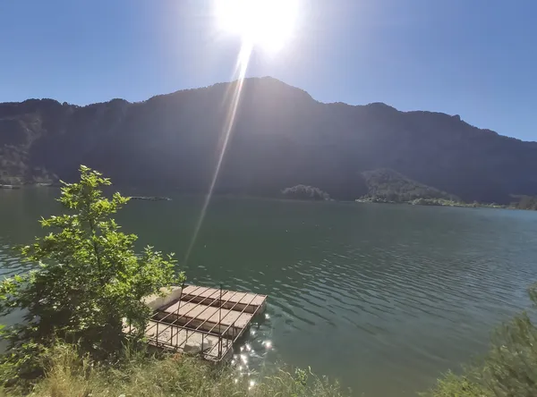 Güneşli bir günde Karacaören Barajı'nda sakin göl manzarası.