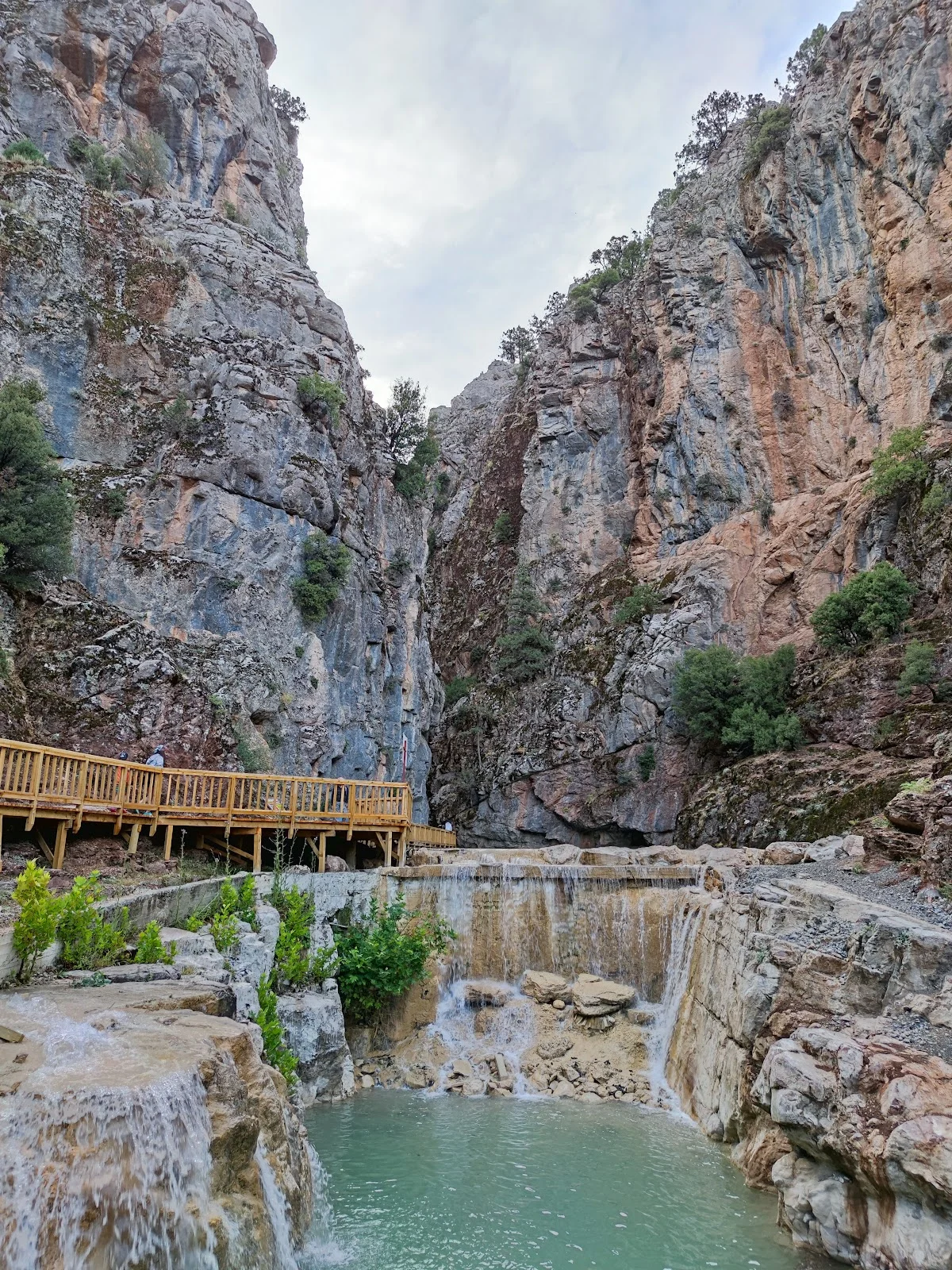 Büyüleyici Manzara! Şelale ve Göletle Çevrili Kanyon Yüksek kayalıklarla çevrili kanyon, şelale ve gölet manzarası.