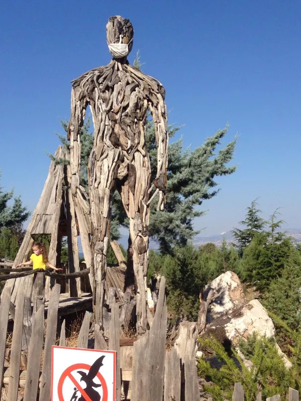 Tahta heykel, beyaz maske, çocuk ve doğal manzara