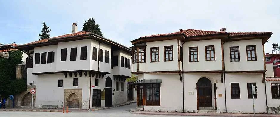 Mısırlılar Evi - Burdur'un Tarihi Mimari Güzelliği mi, Kültürel Mirasın Simgesi mi? Geleneksel Türk mimarisine ait iki yapı, ahşap detaylar ve yeşilliklerle çevrili.