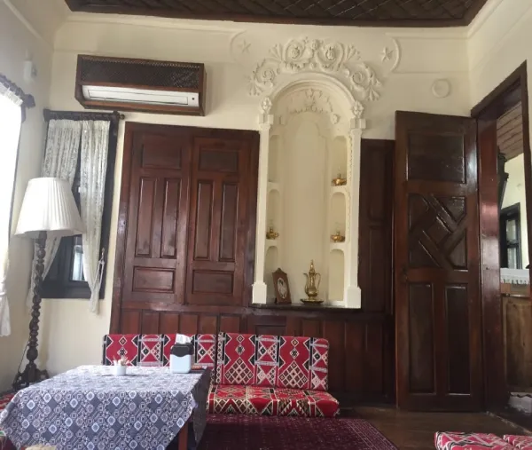 Açık renk duvarlar ve koyu ahşap kapılarla sıcak bir oturma alanı