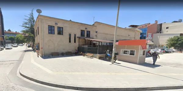 Tarihi Pirkulzade Kütüphanesi önünde dinlenen insanlar ve modern yapılar.