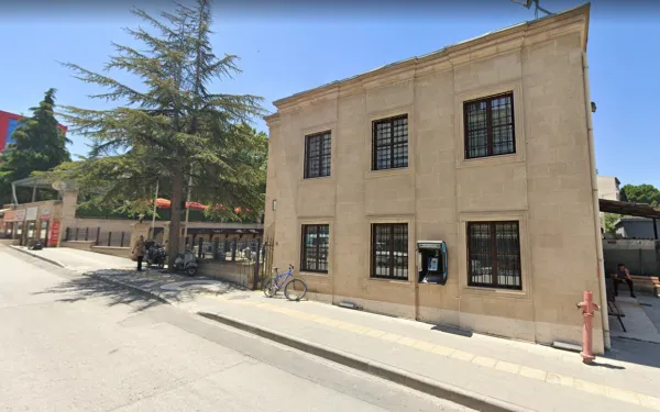 Tarihi Pirkulzade Kütüphanesi, açık renkli taşlarla inşa edilmiş, önünde bisiklet ve motosikletler var.