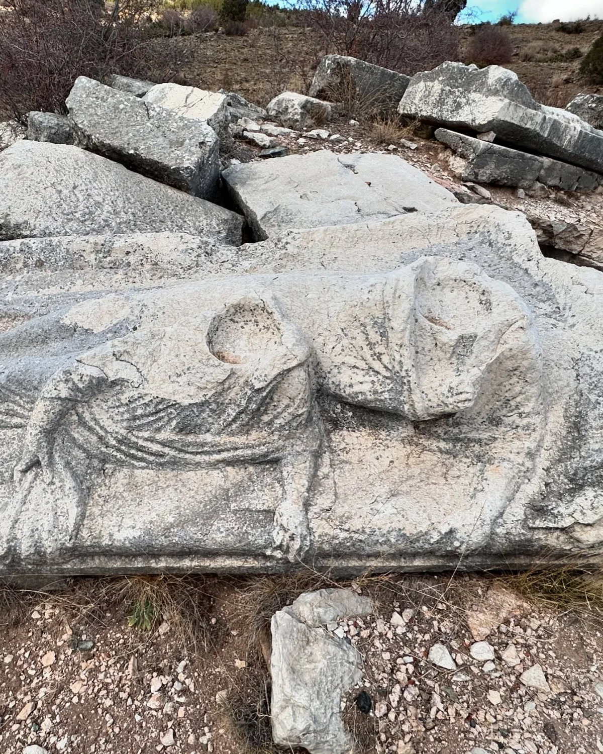 Balboura Antik Kenti'nde Heykel Kalıntısı - Doğanın Kucakladığı Tarih! Büyük taşlar arasında, iki figürle süslenmiş heykel parçası doğal bitki örtüsüyle çevrili.