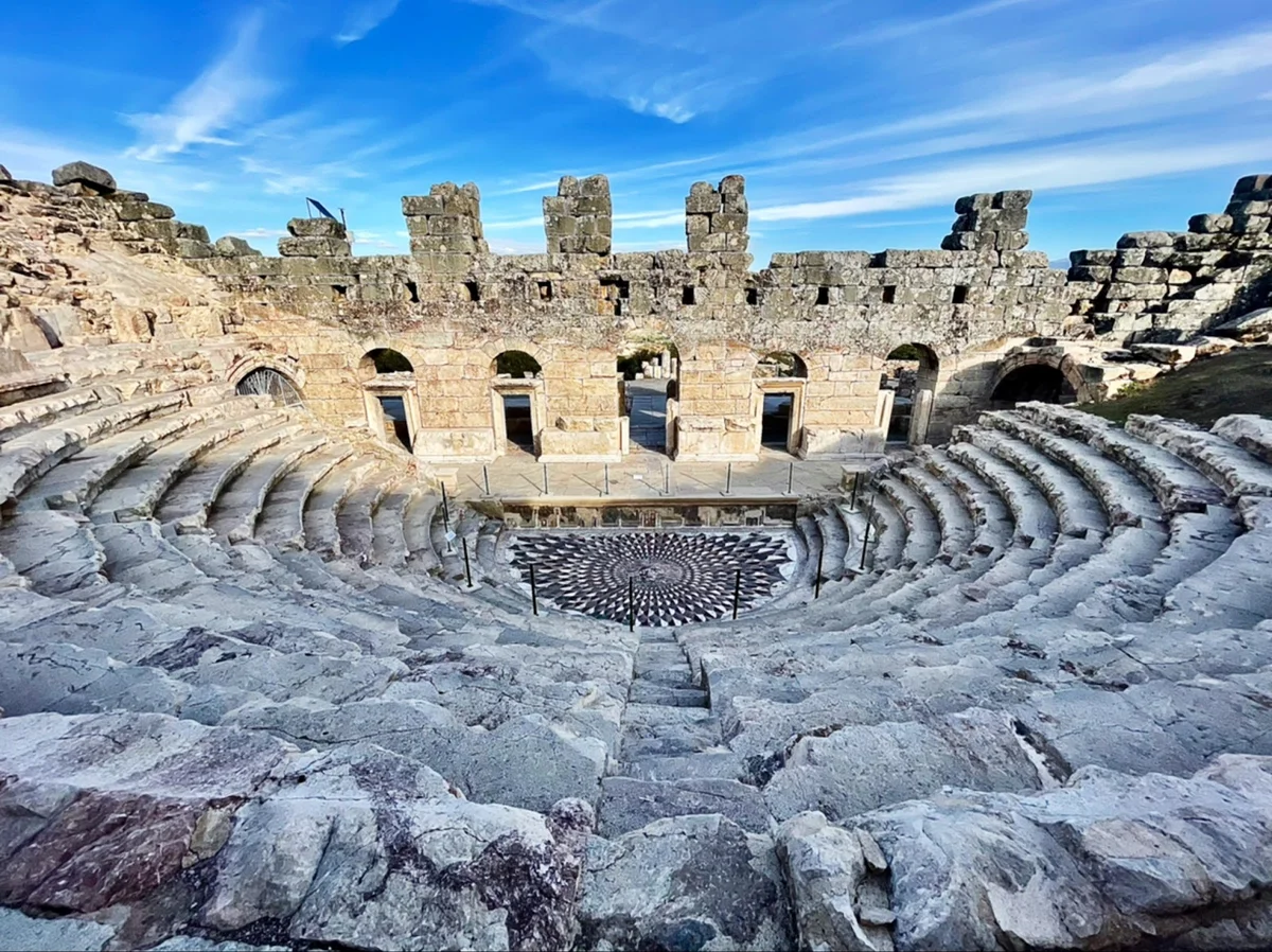 Tarihin İzinde - Antik tiyatro yapısı, taş oturma alanları ve spiral desenli sahne Antik tiyatro yapısı, taş oturma alanları ve spiral desenli sahne.