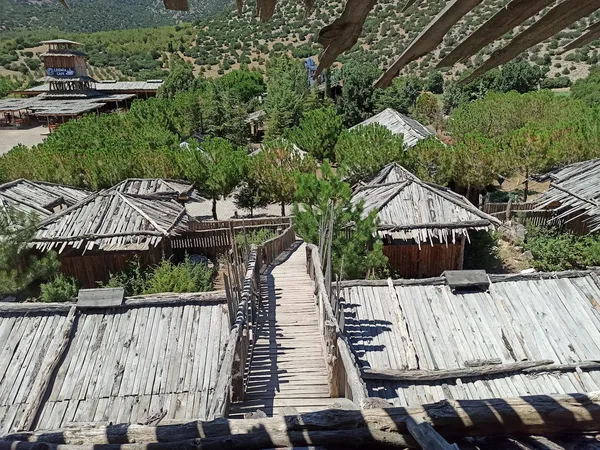 Doğal çevrede ahşap yapılar ve yeşil ağaçlarla dolu huzur dolu bir turizm alanı.