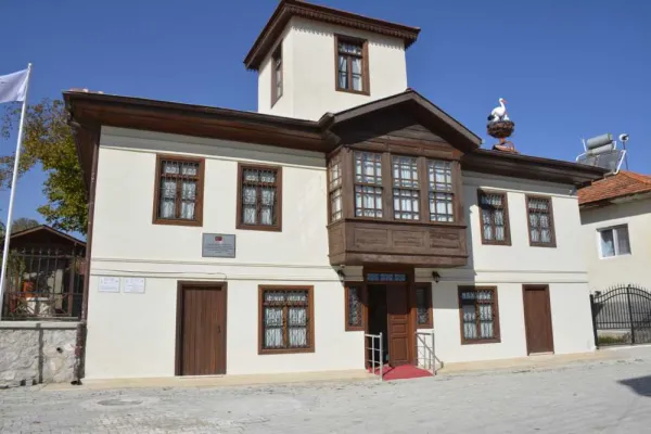 Geleneksel mimari tarzda iki katlı kültür evi, geniş pencereler ve ahşap detaylar ile dikkat çekiyor.